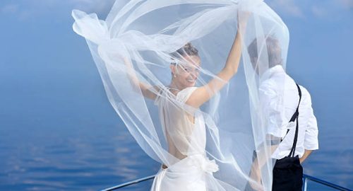 Happy bride and groom hugging on a yacht